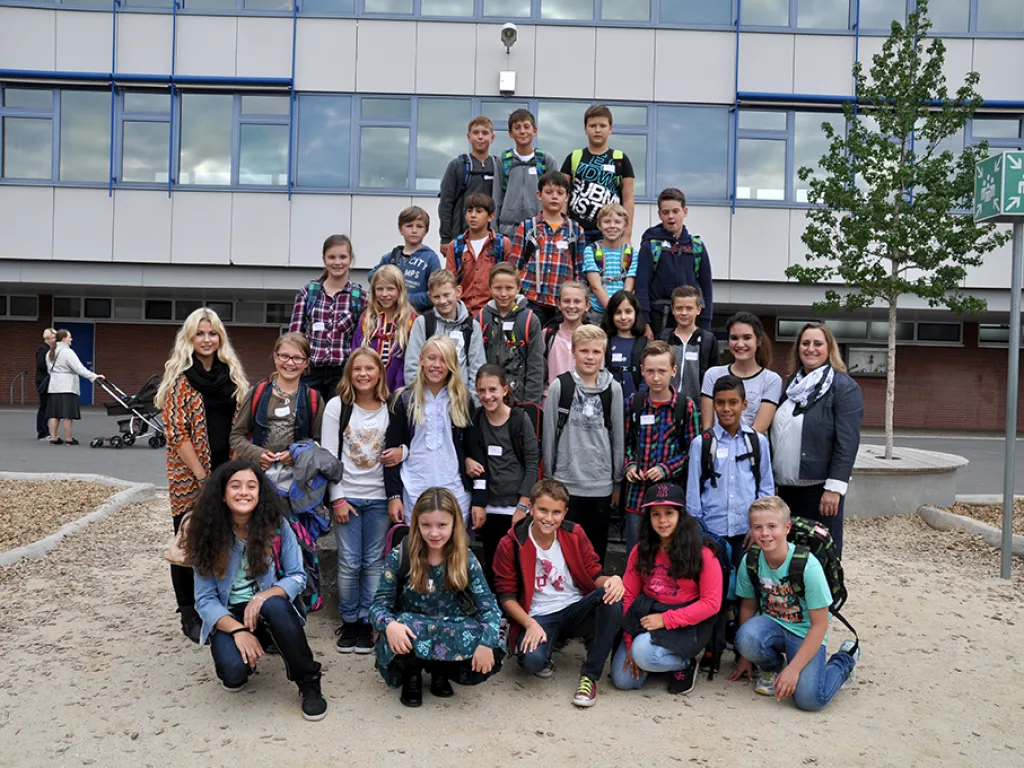 Klassenfoto einer neuen fünften Klasse vor der blauen Fassade.